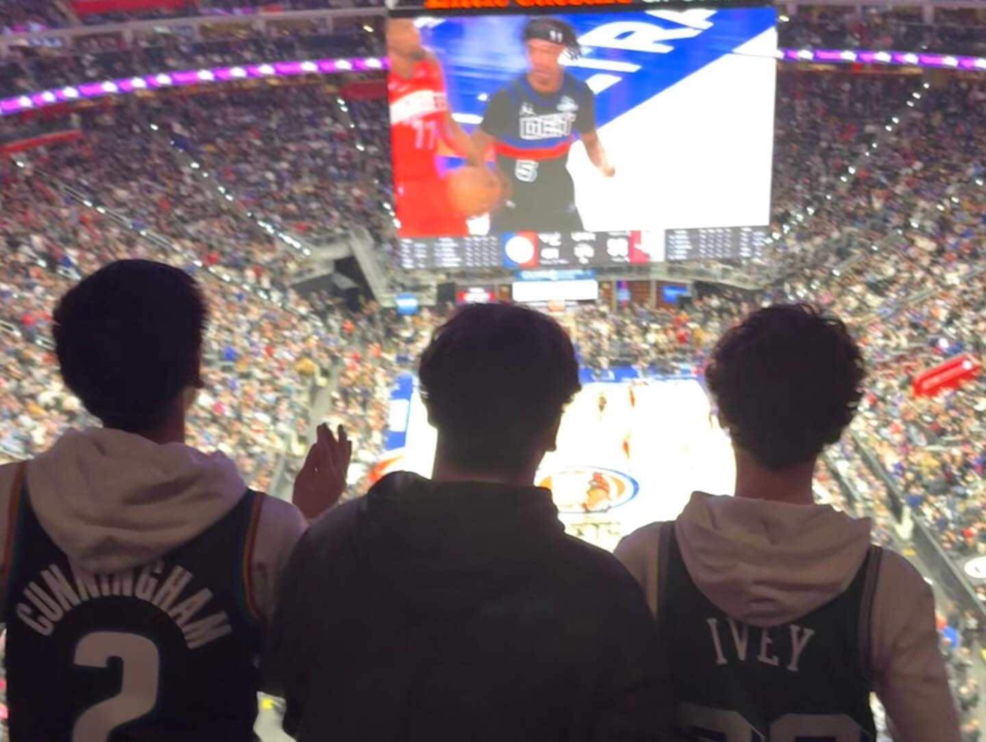 Youth watching a basketball game from arena seats